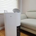 LG 휘센 오브제컬렉션 제습기 DQ134MWEC 거실 설치 모습 - Useful Life Hub 거실 소파 옆에 놓인 흰색 LG 휘센 오브제컬렉션 제습기 DQ134MWEC, 하단에 투명 물통이 보이는 모습